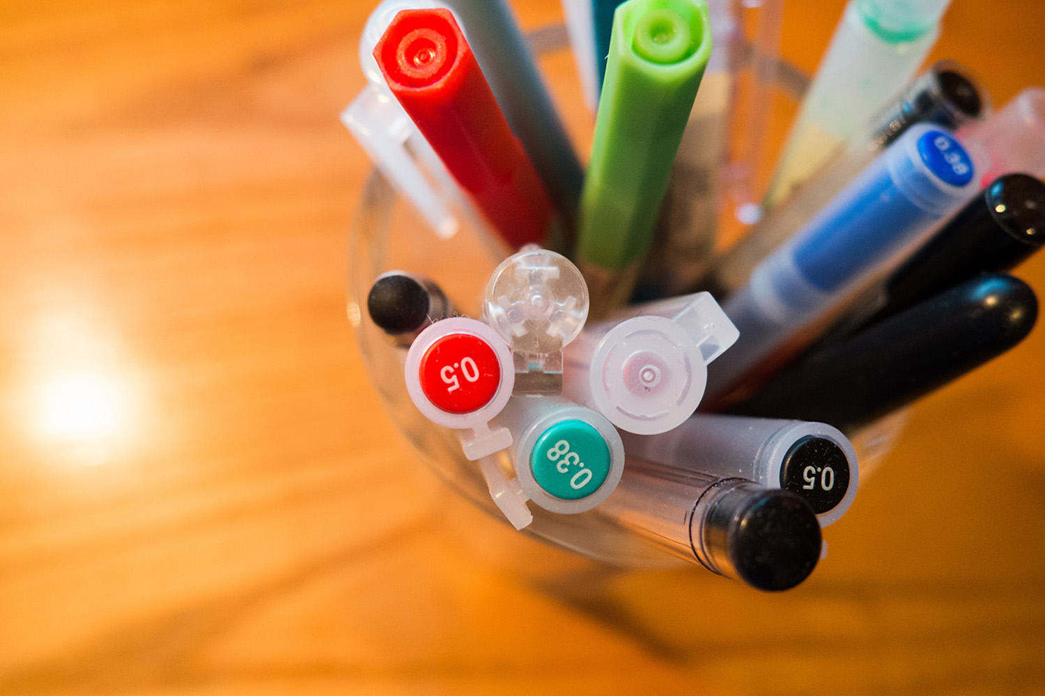A pot filled with coloured pens